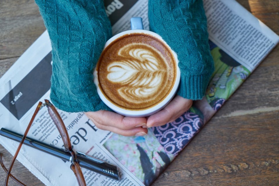 newspaper coffee hands pen glasses