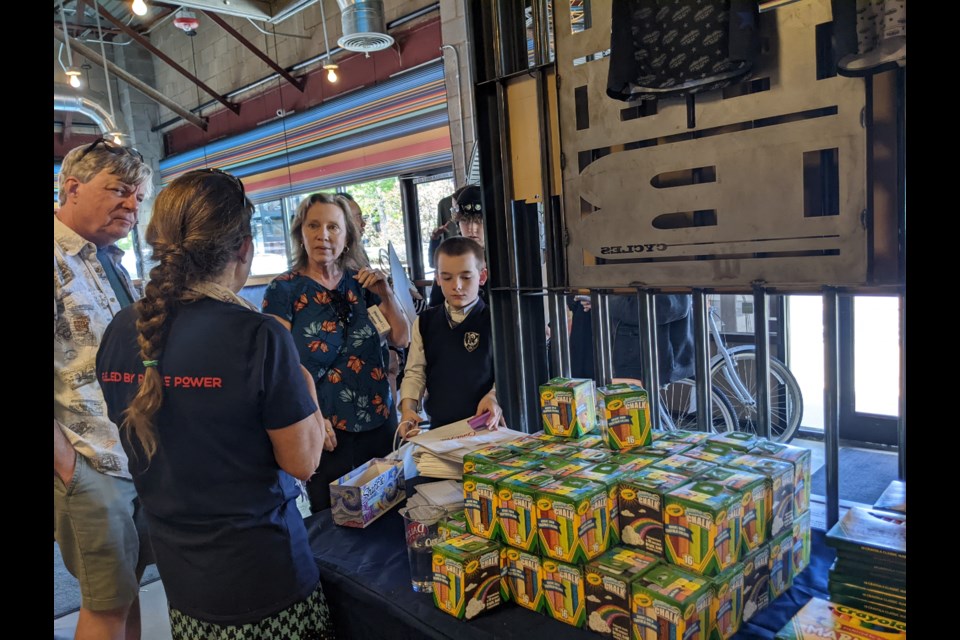 Volunteers get ready to assemble art kits for Colorado foster children during an event Wednesday at CYCLHOPS Bike CANtina.