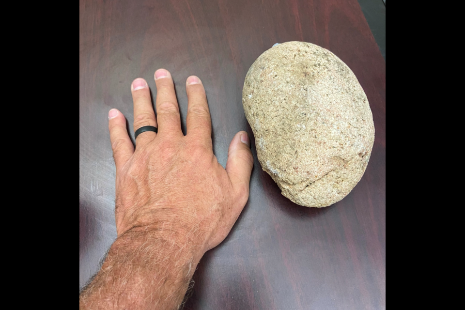 The rock that was thrown by Roker, with a hand for scale.
