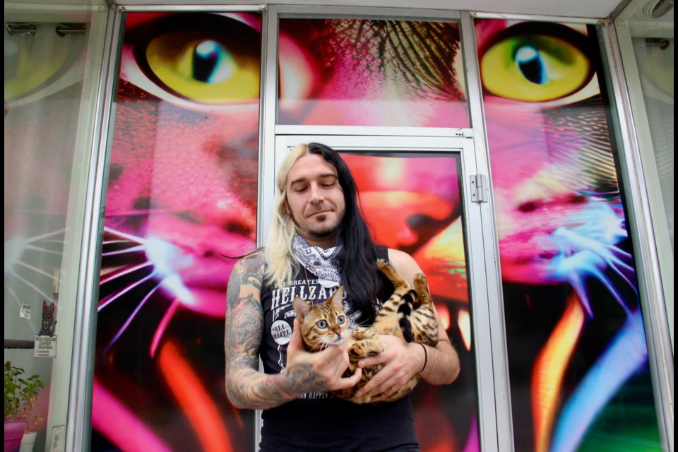 Mikey "Fivebucks" White is seen with his Bengal cat, Nymeria, outside his shop, Catnip Dispensary, in Midland.