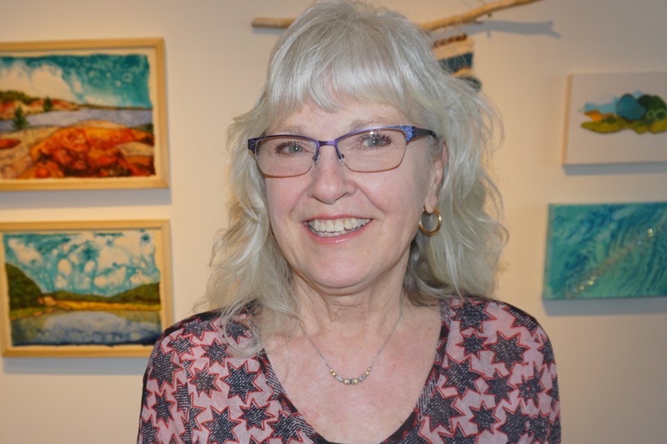 Frieda Ambroziak is pictured in front of her two paintings (on the left in the photo) submitted for the exhibition. Andrew Philips/MidlandToday                           
