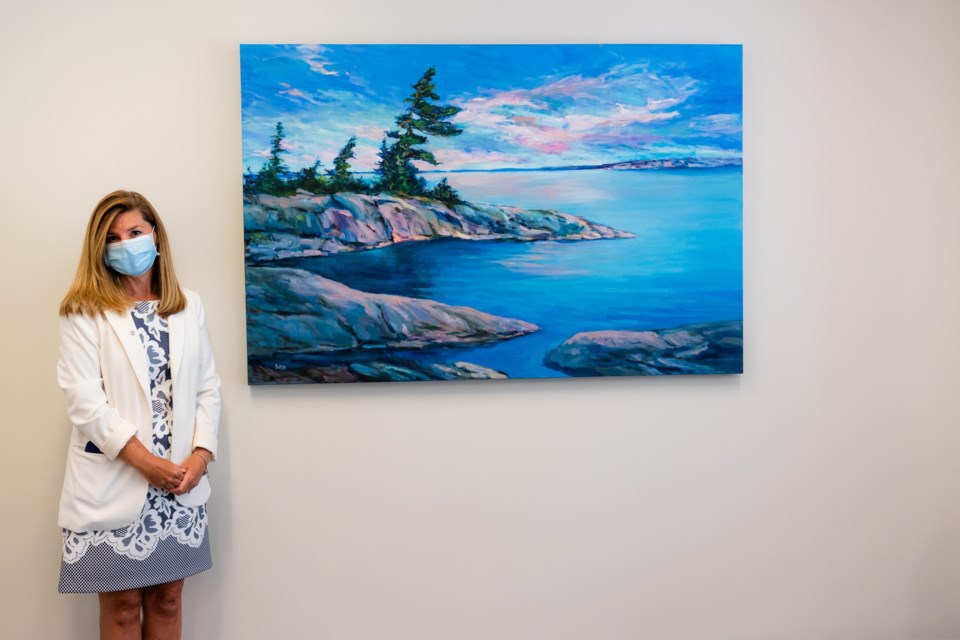 Local artist Cathy Boyd recently donated an original oil painting,  ‘Spirit of Georgian Bay’, to Georgian Bay General Hospital. The vibrant art piece is displayed in the main conference room, on the hospital’s lower level. Christine Baguley, from the GBGH  
Foundation, is shown with the painting.
