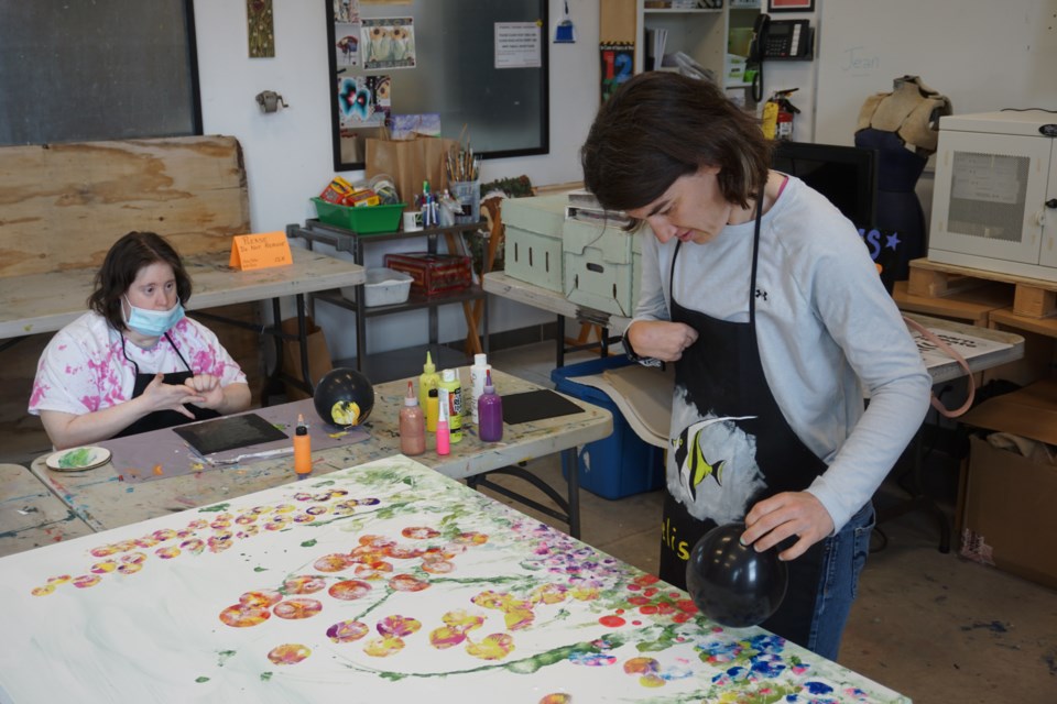 Melissa MacDonald uses a balloon to create a flower for the large group painting.