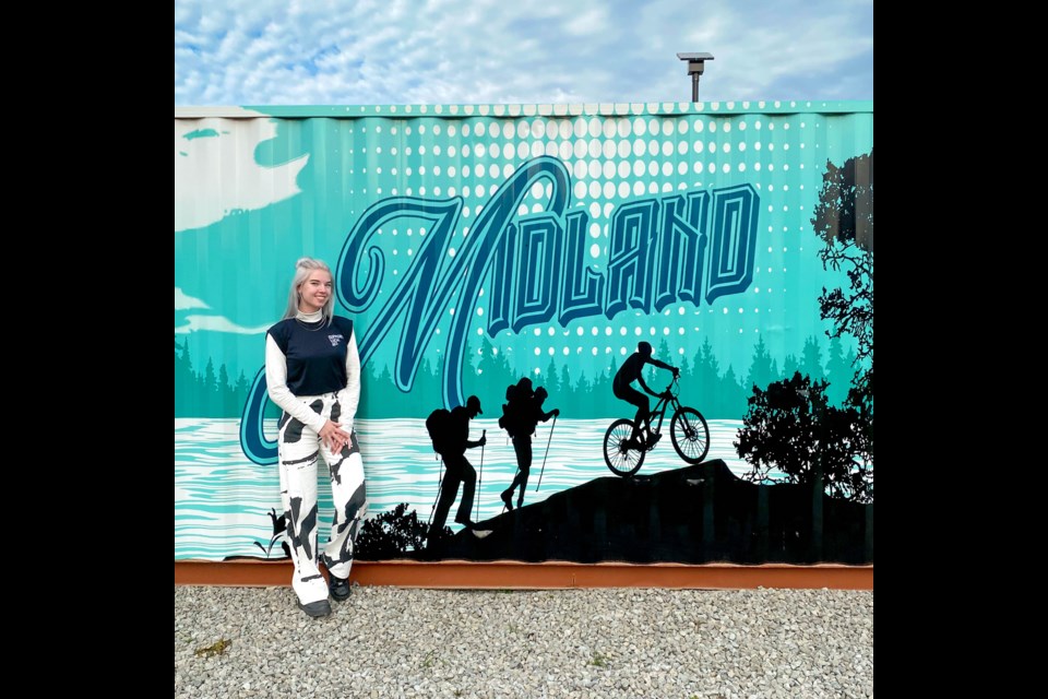 Alex Kostecka-Silva stands in front of her design used for Midland sea can project.