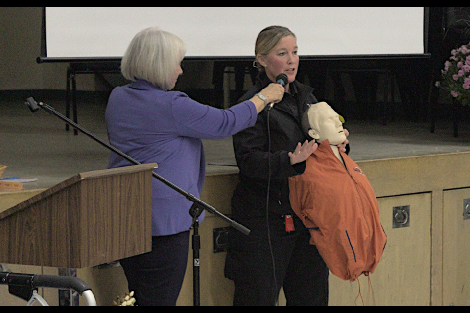 Kim Oxley (right), coordinator for the Public Access Defibrillator program with the Simcoe County Paramedic Services, gave a real-time demonstration of the life-saving device to the Tay Seniors Symposium. Helping with audio was Cathy Greer, who alternated the microphone between Oxley and the speaker on the automated defibrillator.