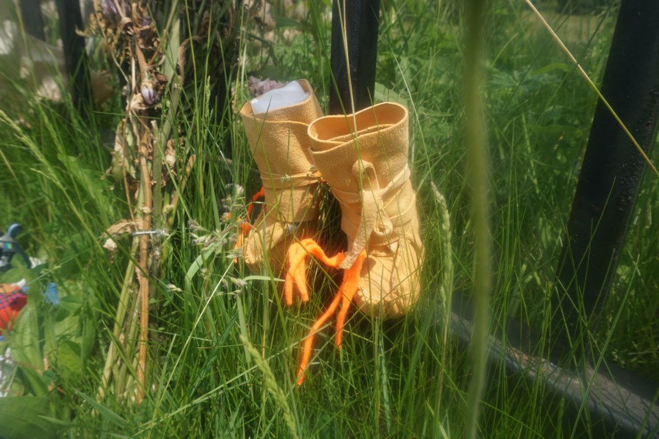 Teddy bears, flowers, sneakers and tiny handmade moccasins are just a few of the items dotting the Martyrs' Shrine’s west gate these days           