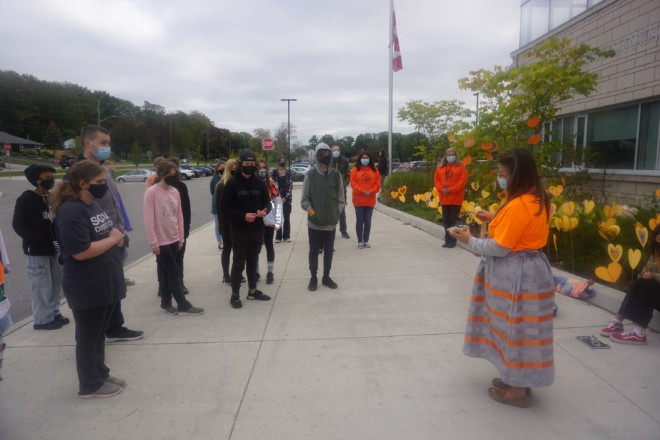 Aimee Grenier-Buchwald performs a smudging ceremony as students return from their walk.                       