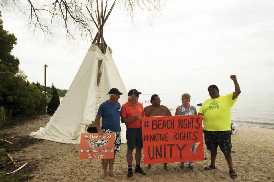 Johnny Hawke, far right, set up an encampment on a Tiny beach last summer to bring attention to beach rights.