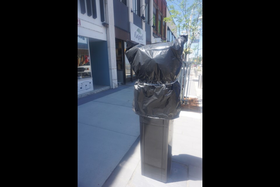 One of the new parking meters remains covered with a garbage bag downtown.