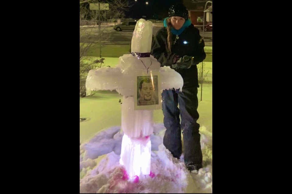 Angela Vos places a cross she crafted out of ice at Ross Memorial hospital in Lindsay.