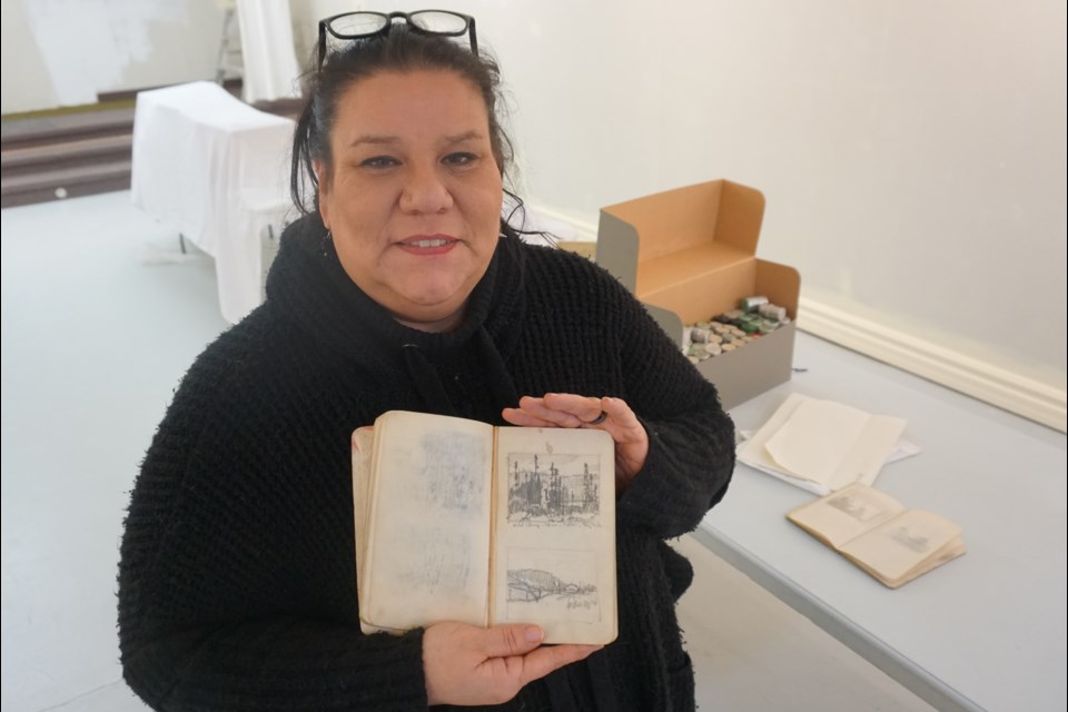 Huronia Museum executive director Nahanni Born holds one of Franz Johnston's sketchbooks. The museum hosts a special event Saturday to unveil some recently discovered Group of Seven treasures.