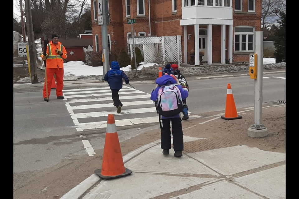 Carl Wright helps students get safely across County Road 93 in Hillsdale.