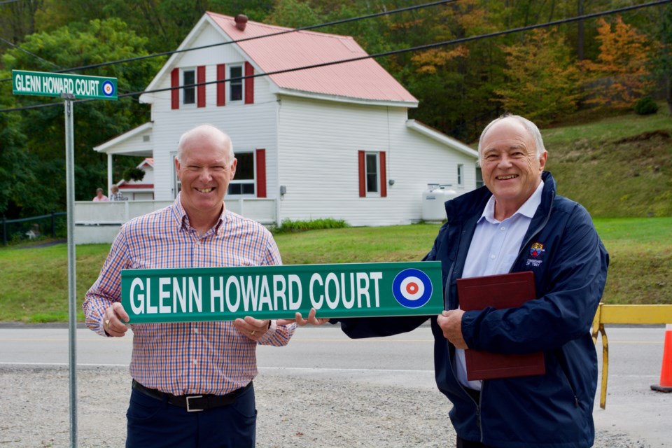 Glenn Howard, left, holds the new street sign with Tiny Mayor George Cornell.