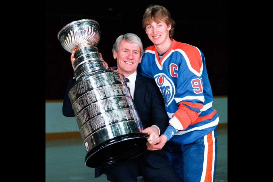 John Muckler poses with Wayne Gretzky and the Stanley Cup.