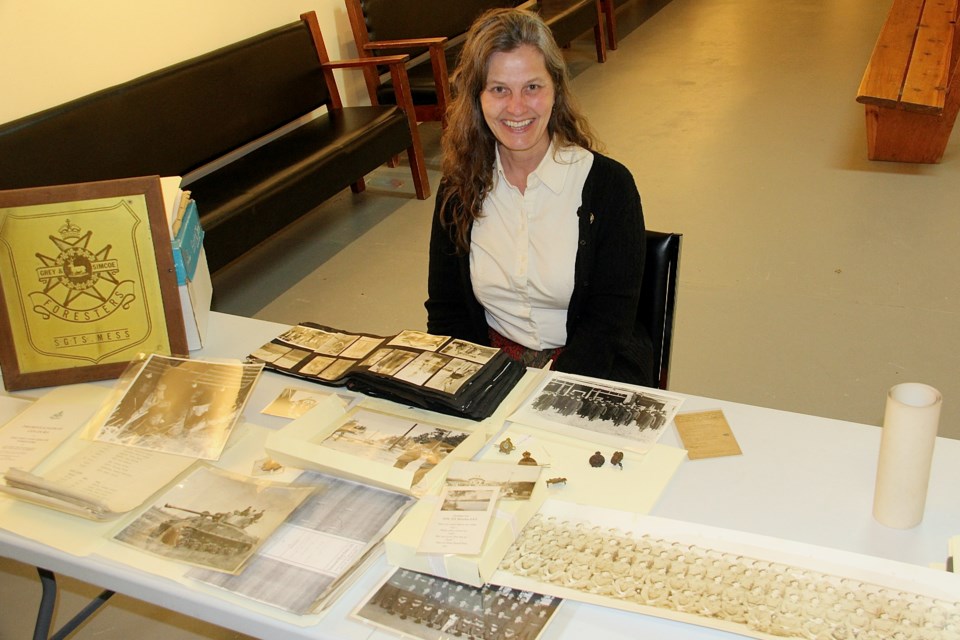 Genevieve Carter, curator of the Huronia Museum in Midland sits with some of the artifacts from the Grey and Simcoe Foresters.
