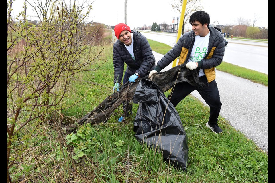 Ameet Penkar,left, and Vihaan Bapat with the Milton Hindu Community Group work to clean up the green spaces alongside Derry Road near Fourth Line during the annual Good Neighbours Day. The community-led, volunteer neighbourhood clean-up program returned after a four-year hiatus.
