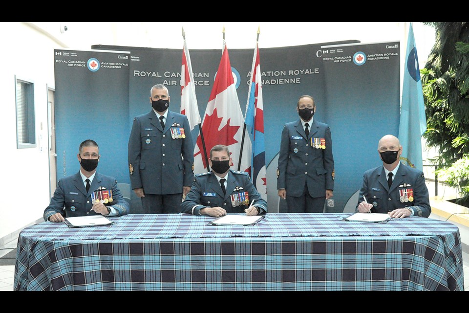 Col. Jonathan Bouchard (front left) officially signs on as the new Wing Commander at 15 Wing alongside reviewing officer Brig. Gen. Denis O’Reilly (centre) and outgoing Wing Commander Col. Ron Walker.