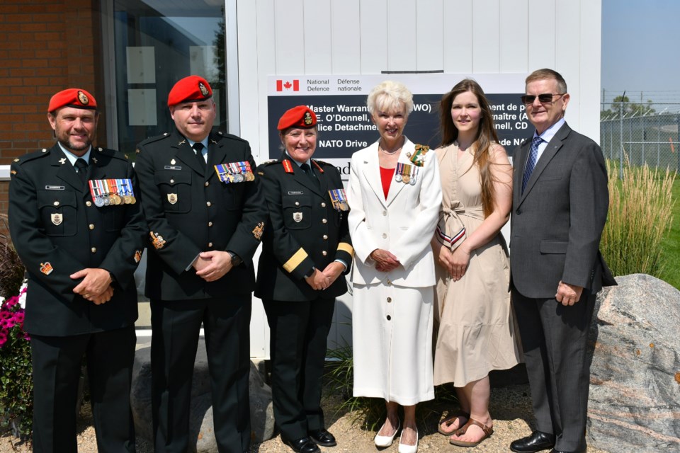 Dignitaries and family gather in front of the new sign at the building renamed in honour of MWO N.E. O’Donnell, CD. From left: Warrant Officer M.L. Sanders, Chief Warrant Officer Dube, Brig.-Gen. Vanessa Hanrahan, Lieutenant-Governor Bernadette McIntyre, Kimberley O’Donnell, and Richard Hansen.