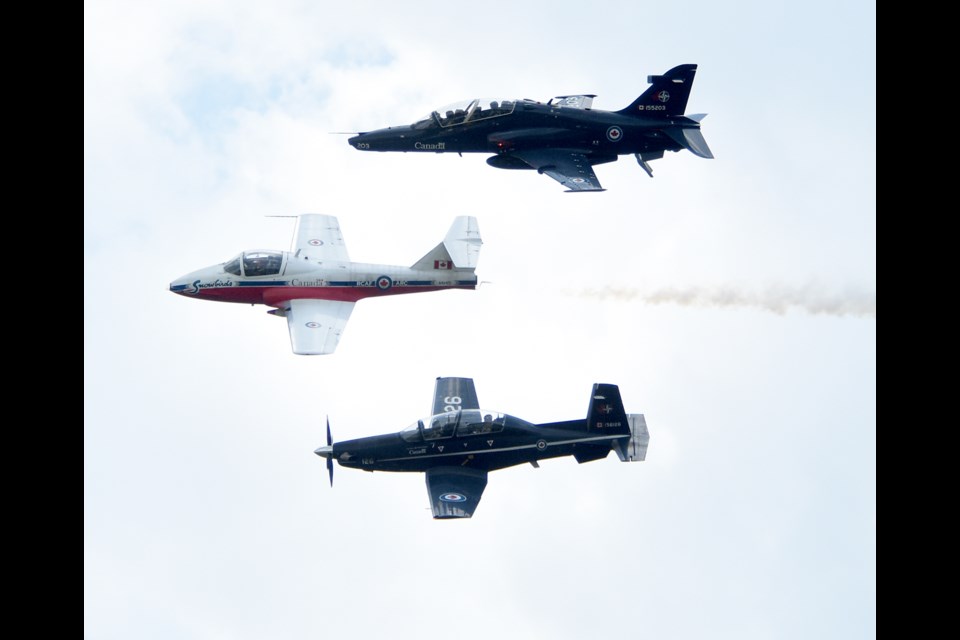 A Hawk trainer jet, Snowbirds Tutor jet and Harvard trainer fly by during the opening ceremonies.