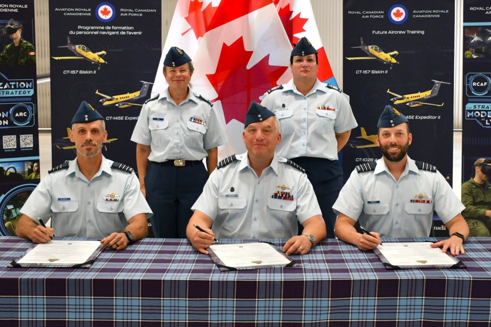 New 2 CFFTS commander LCol Craig Cloete (front left) signs the official documents during the change of command СƵ at 15 Wing, alongside Col Adam Carlson (front centre) and outgoing commandant LCol Philippe Turcotte (front right) on July 4.