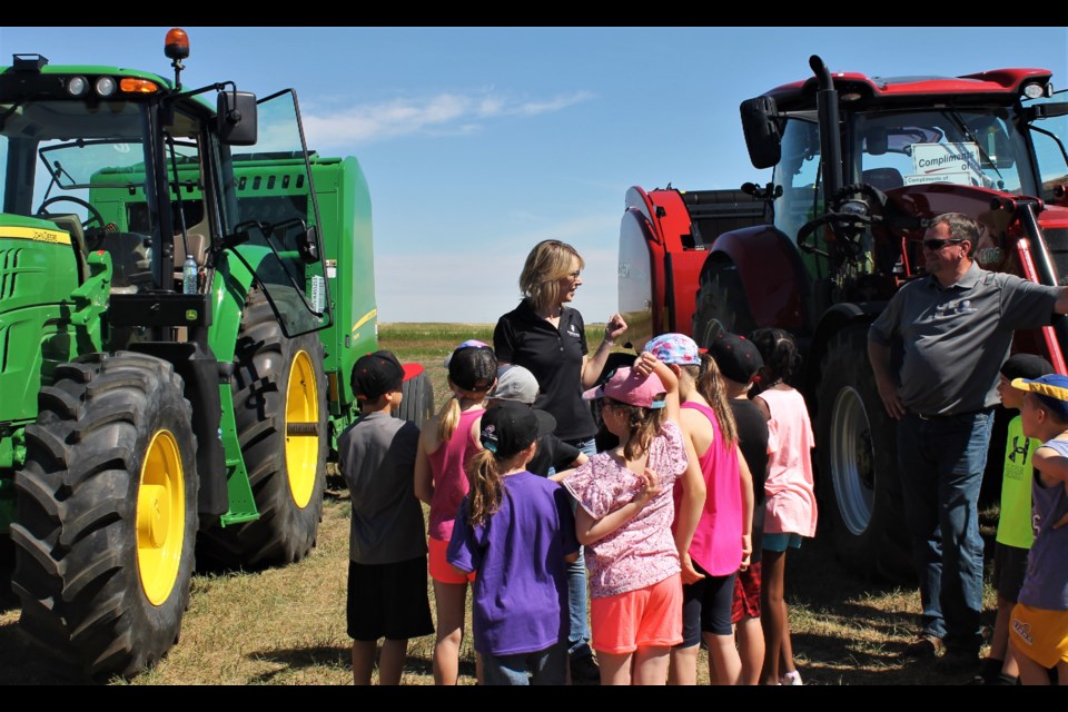 Representatives from South Country Equipment and Young’s Equipment explain what this machinery is and what it does: tractors and balers to make bales.