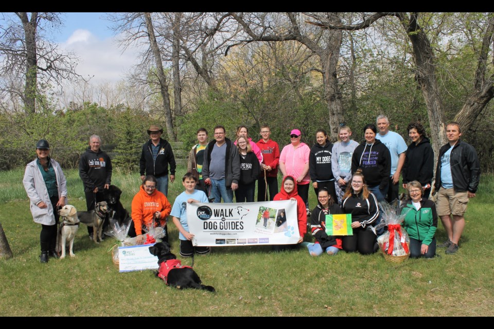 The walkers gathered in Wellesley Park, furry companions at their side.