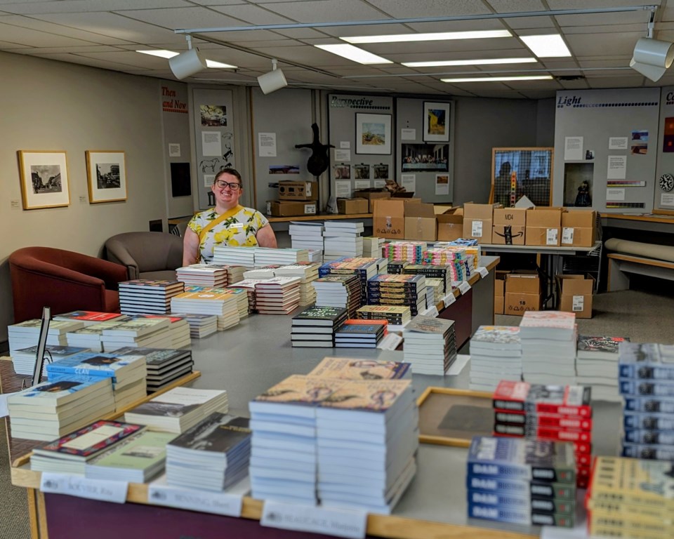 amanda-farnel-executive-director-of-the-saskatchewan-festival-of-words-stands-in-the-festivals-temporary-bookstore-in-the-mjmag-basement