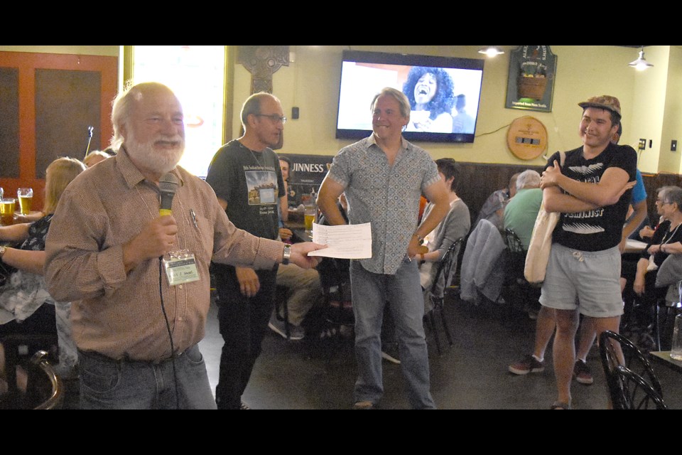 Former Moose Jaw mayor and long-time MLA Glenn Hagel auctions off a group of authors including Ted Barris, Drew Hayden Taylor and Billy-Ray Belcourt.