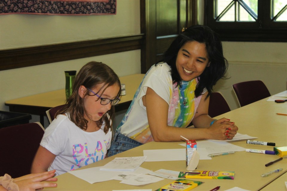 Jillian Tamaki jokes with one of the workshop participants, asking about her self-portraits.