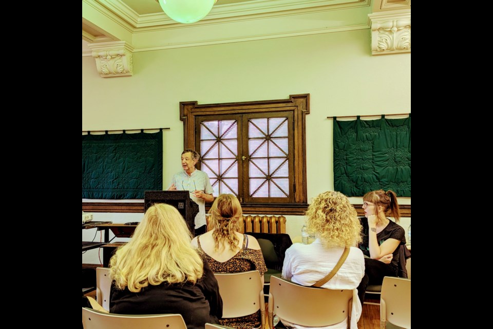 Guy Gavriel Kay speaks to an audience at the Moose Jaw Public Library as co-presenter Casey Plett listens