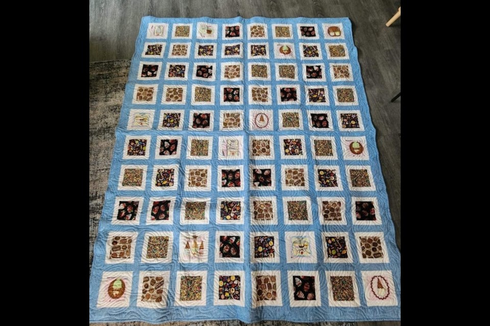 The quilt measures 68 inches (172.72 cm) by 84 inches (213.36 cm) and includes a sweet-toothed theme.