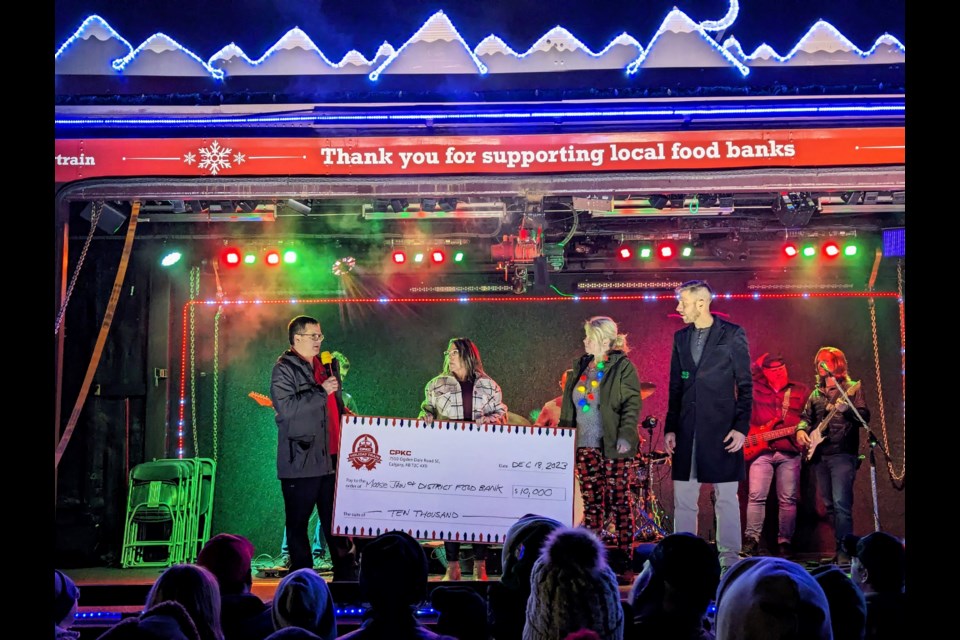 (l-r) Tim Wonsiak, Gabrielle Belanger, and Terri Smith step onstage to announce the total funds raised by the 2023 Good Buy to Hunger food drive for the Moose Jaw Food Bank