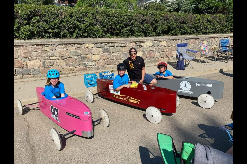 Roger Pilloud and his three kids Mya, Jasper, and Leo, in their soap box derby car.