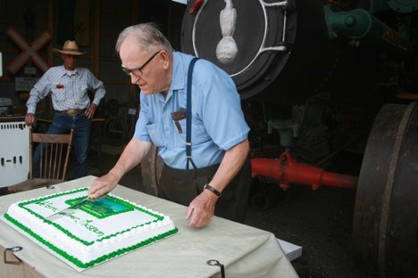 Alfred Volman cuts a cake. Photo by Ron Walter
