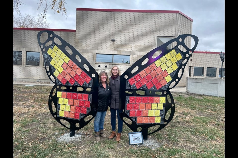 Crystal Thorburn and Alison Lewis stand together with the completed butterfly