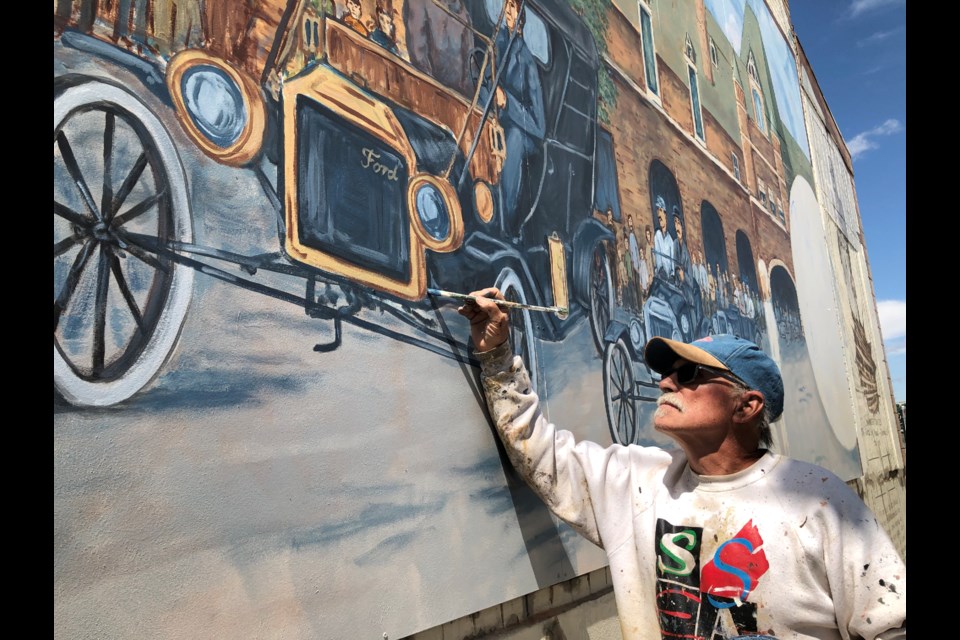 Artist Grant McLaughlin works on one of the Model T Fords in the "Baseball" mural in 2020. Photo by Jason G. Antonio 