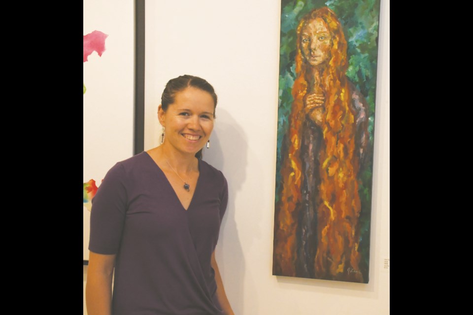 Jess Zoerb stands beside a portrait she created and that is now on display at the Moose Jaw Cultural Centre, as part of showcase featuring 16 other artists from the community. Photo by Jason G. Antonio