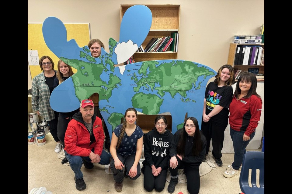 Students from A.E. Peacock Collegiate's art club gather with curling organizers to celebrate the creation of their artwork, which features the world map on a moose. In the picture, in no particular order, are Cori Saas (teacher), sisters Anna and Mia Fullerton, Jessica Haubl, Kaylee Jensen, Keaton Atherton, and Sara Leptin, and curling vice-chairs Heather Eby and Devon Oleniuk. Photo by Jason G. Antonio