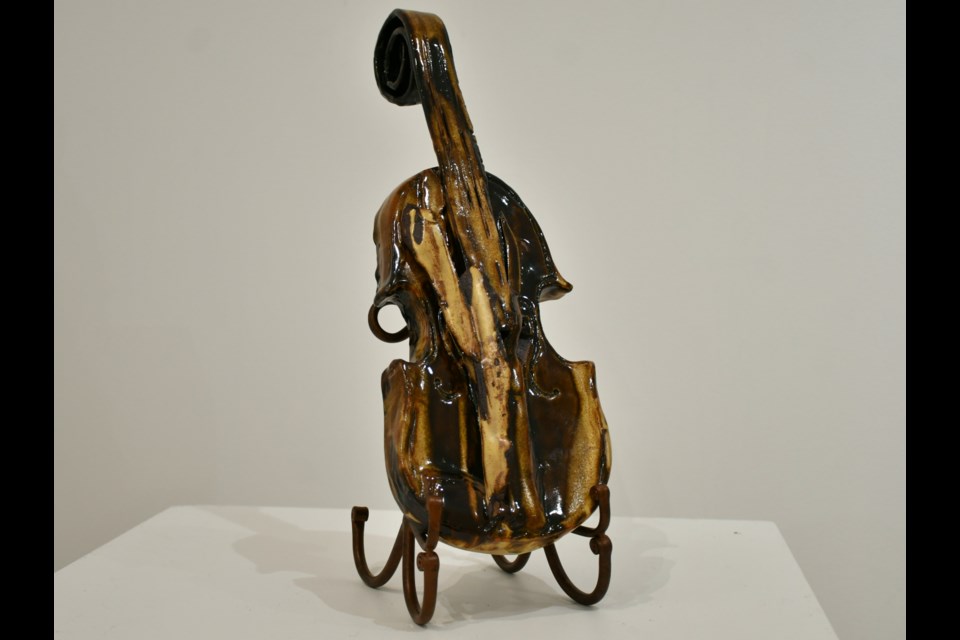 A sculptural clay violin by Dorothy Yakiwchuk, featured in her solo exhibit “Inspiration in Clay.” The abstract piece reflects her lifelong love of music and creative expression.