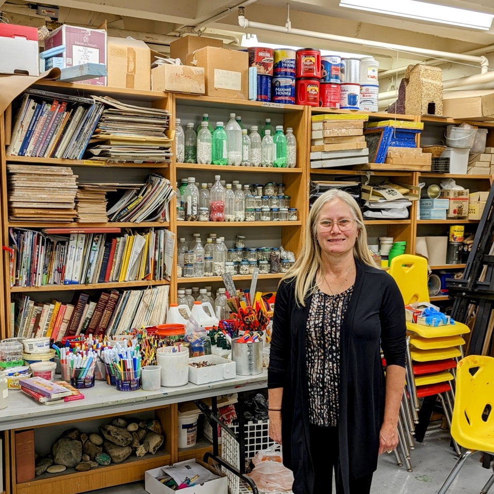 Christy Schweiger stands amidst art supplies in the MJMAG