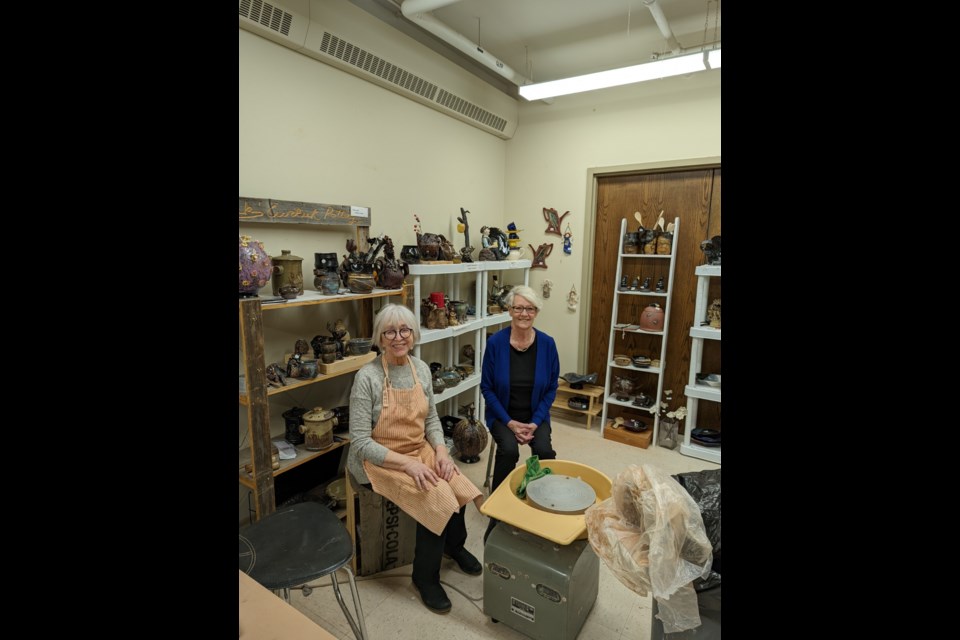 The Mud Pie Girls, Dorothy Yakiwchuk (left) and Kathy Verbeke (right) together in their studio at the Cultural Centre. They are surrounded by pottery and sculptures in various stages of hand-building, throwing, firing, drying, and glazing