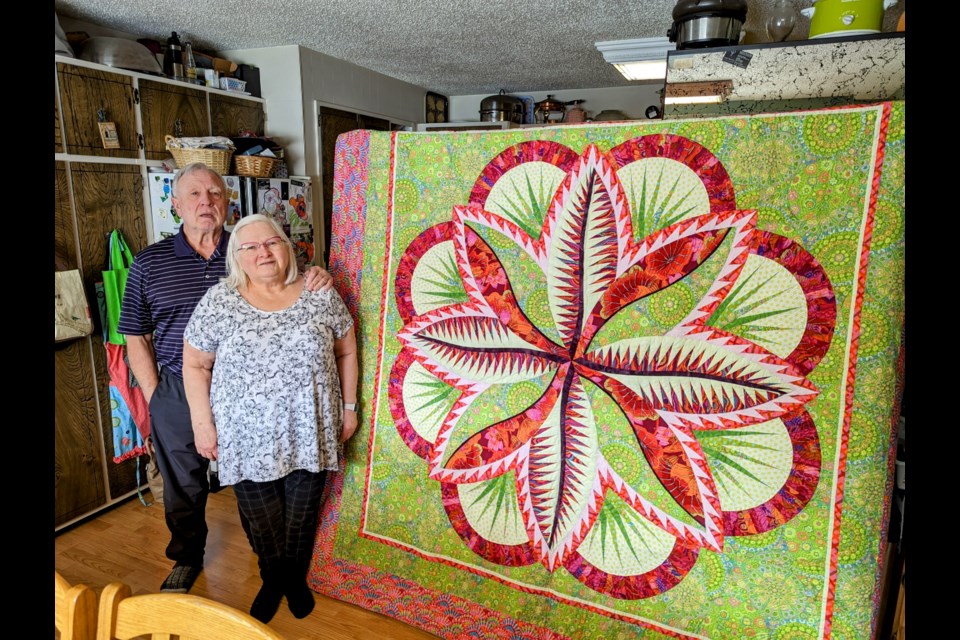 Craig and Colleen Lawrence with one of the quilts they are preparing for the Sew Full of Whimsy show in April