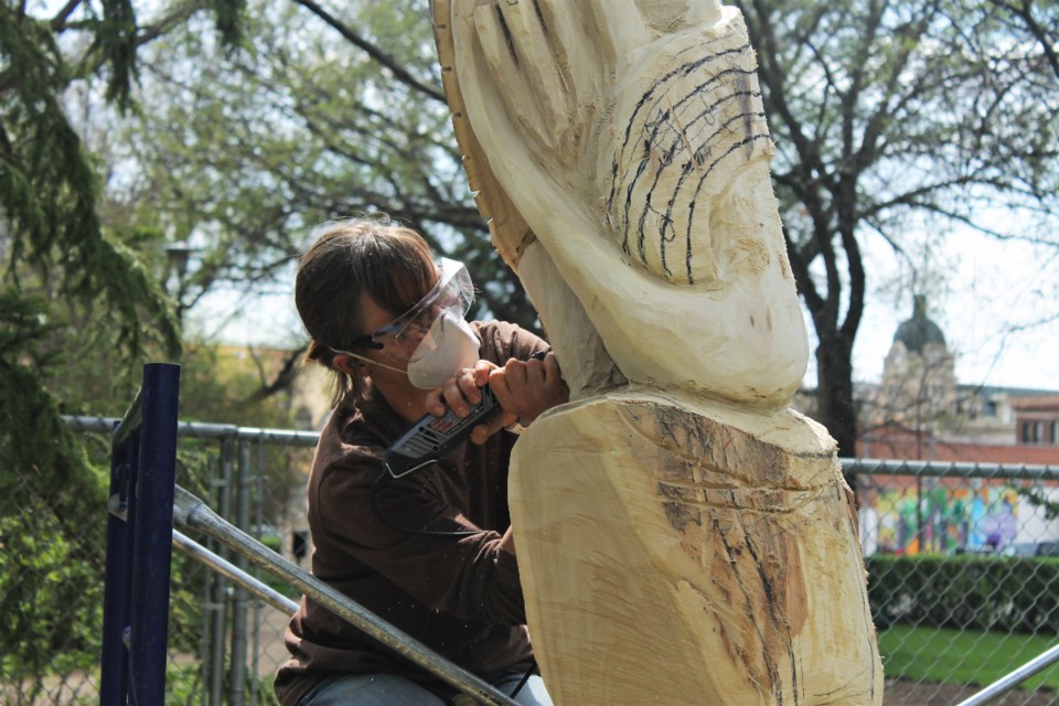 Artist Karen Watson working on her chainsaw carving for the Crescent Park Tree Carving Project. 