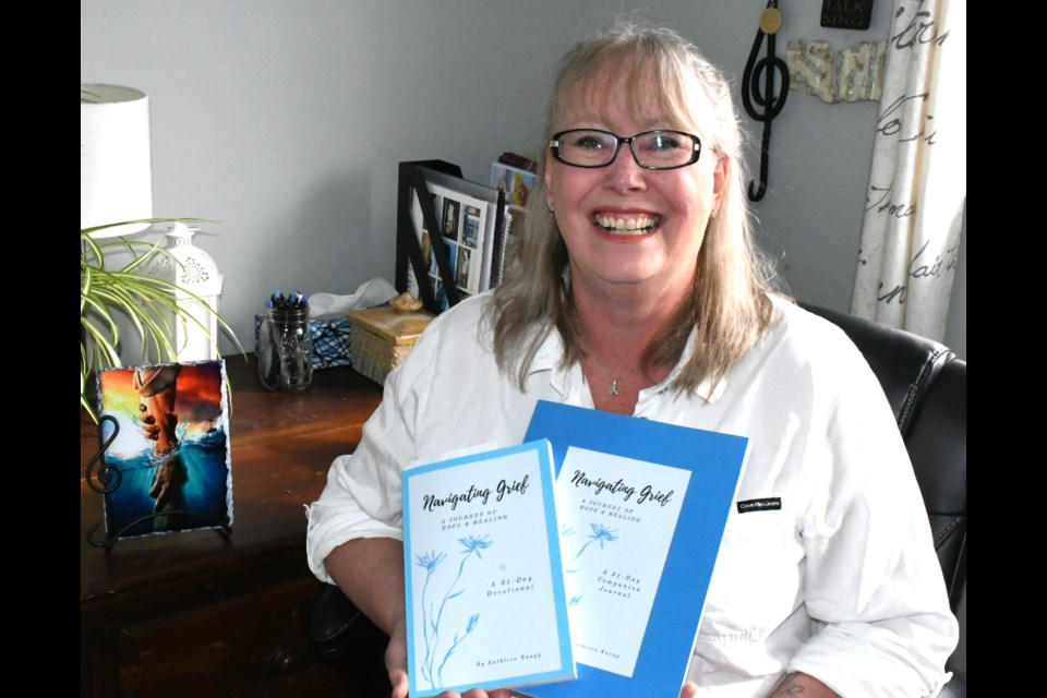 Kathleen Knapp, an author and motivational speaker, holds the devotional and journal she created to help people overcome grief. Photo by Jason G. Antonio