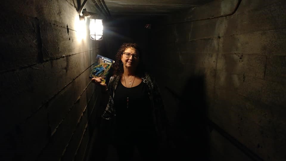 Author Mary Harelkin Bishop poses with a copy of the updated edition of her bestselling novel Tunnels of Time, in the actual Tunnels of Moose Jaw. (supplied)