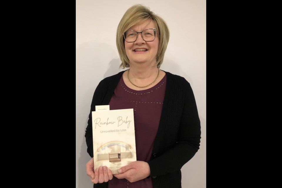 Tamara Wanner holds a copy of her debut fiction novel, "Rainbow Baby: Unravelled by Loss," which focuses on losing a pre-born baby. Photo by Jason G. Antonio