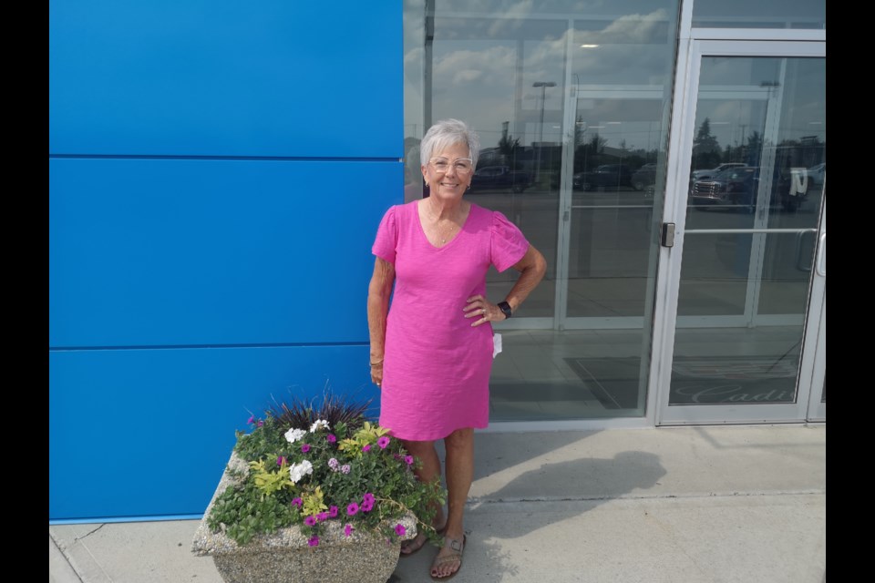 Brenda Reilly stands outside the front entrance to Murray GM where she has worked for the past 26 years.