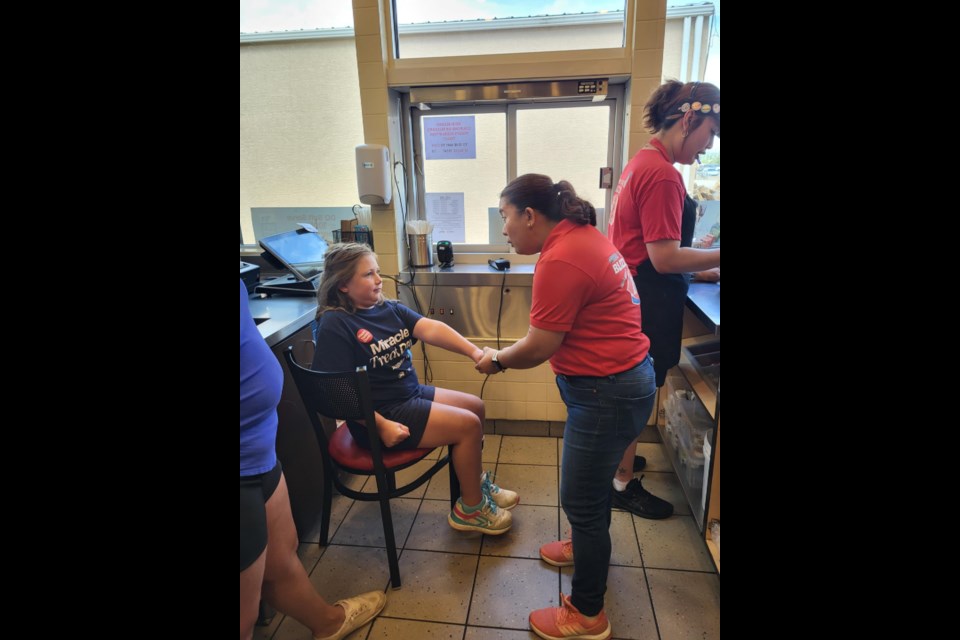 Kortni, a Central Butte girl who was the ambassador for the Jim Pattison Children's Hospital, speaks with manager Ann Angeles about helping at the drive-thru, during the Miracle Treat Day event. Photo courtesy DQ North