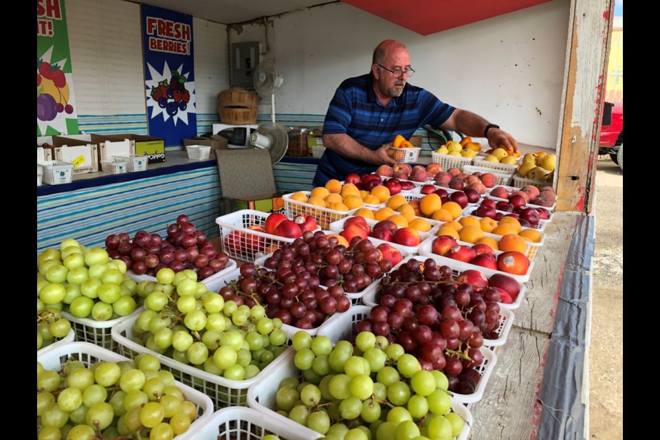 Todd Bell, owner of B&B Fruit Stand, arranges his produce in between customers. Photo by Jason G. Antonio