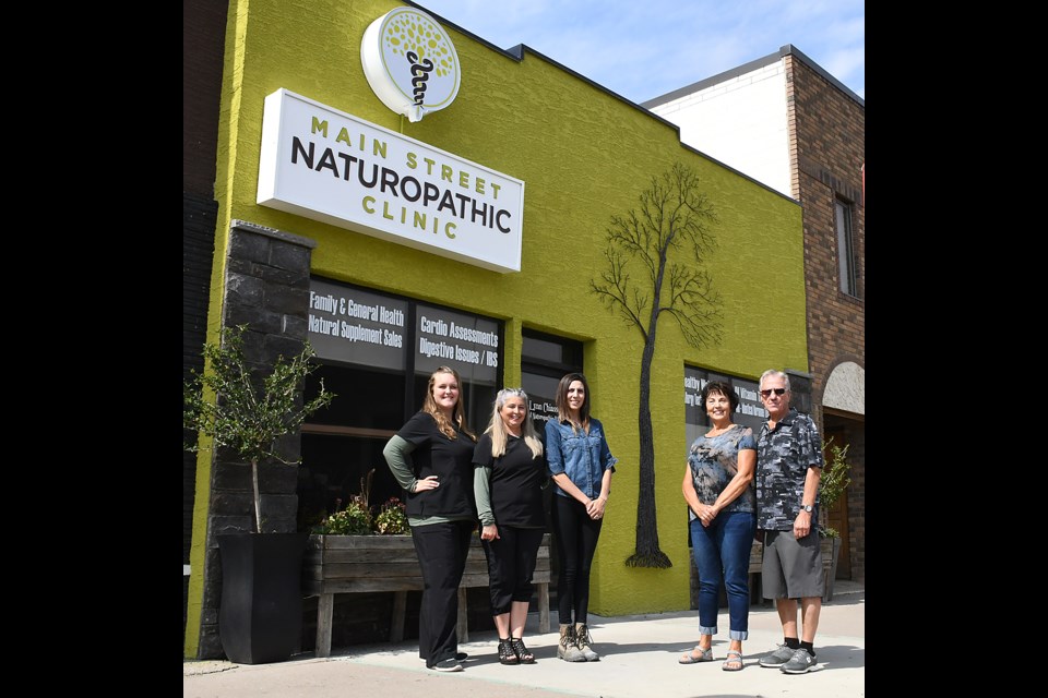Tamara Morgan and Dr. Lynn Chiasson with the Main Street Naturopathic Clinic join Becca Sheets from Sure Fire Signs and Graphics and local artists Laurette and Bill Keen outside the new and improved storefront.